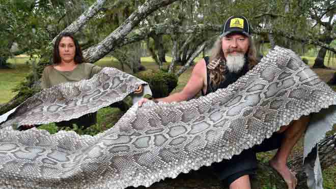 Photo de Dusty Crum et de sa petite amie, tenant une peau de python.