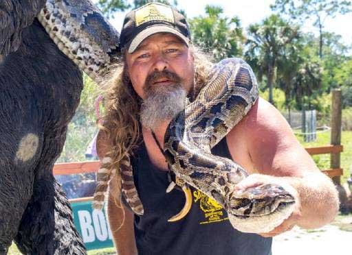 Photo de Dusty Crum portant un python.