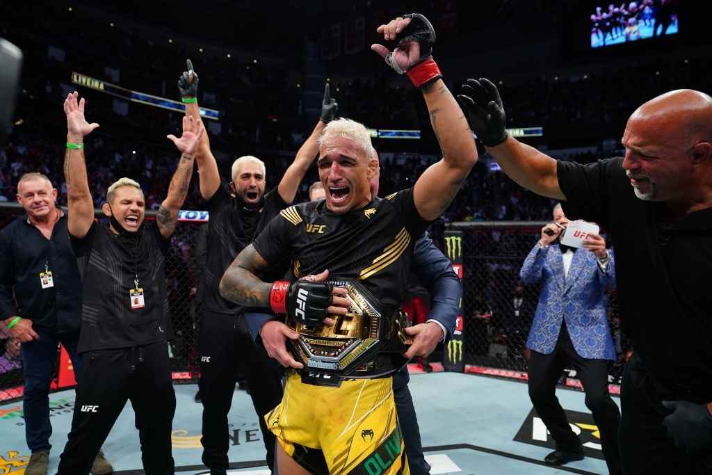 Charles Oliveira du Brésil réagit alors que le président de l'UFC, Dana White, place la ceinture de championnat légère de l'UFC autour de sa taille après avoir battu Michael Chandler au Toyota Center le 15 mai 2021 à Houston, Texas.